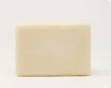 Single ivory olive oil soap bar, unwrapped, on a white background